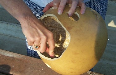 person cleaning the inside of a gourd