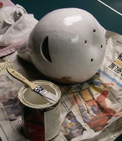 white gourd birdhouse with white paint and a brush